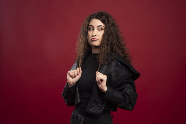 Studio portrait of a woman with a doubtful expression in dark clothing, illustrating trust and legitimacy issues in online services