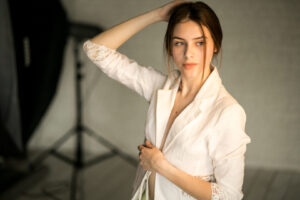 Confident model posing naturally in a studio, showcasing authentic beauty and presence over perfection in modern modeling